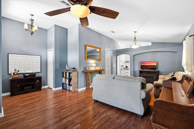 living room featuring a fireplace, dark hardwood / wood-style flooring, ceiling fan with notable chandelier, and vaulted ceiling