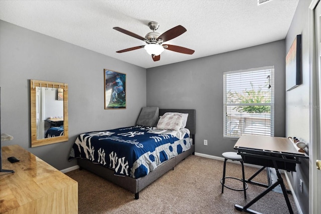 carpeted bedroom featuring a textured ceiling and ceiling fan