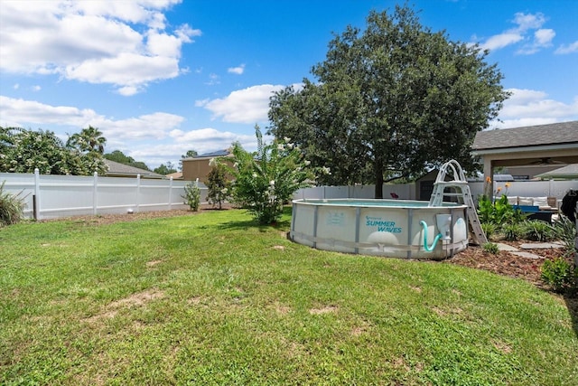 view of yard with a fenced in pool