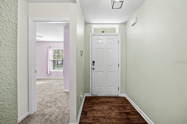 doorway with dark colored carpet and a textured ceiling