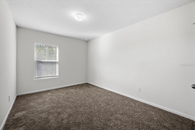 carpeted empty room featuring a textured ceiling