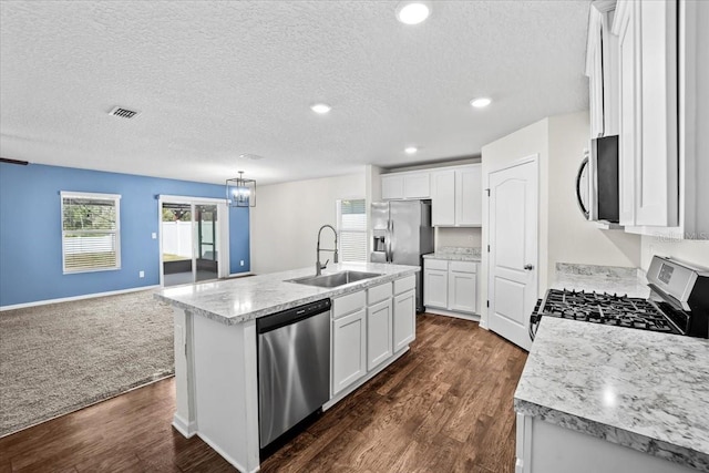 kitchen with white cabinetry, appliances with stainless steel finishes, sink, and a center island with sink