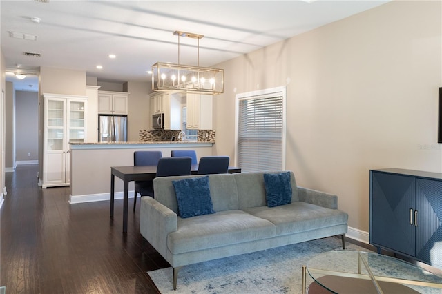 living room featuring dark hardwood / wood-style floors, sink, and an inviting chandelier