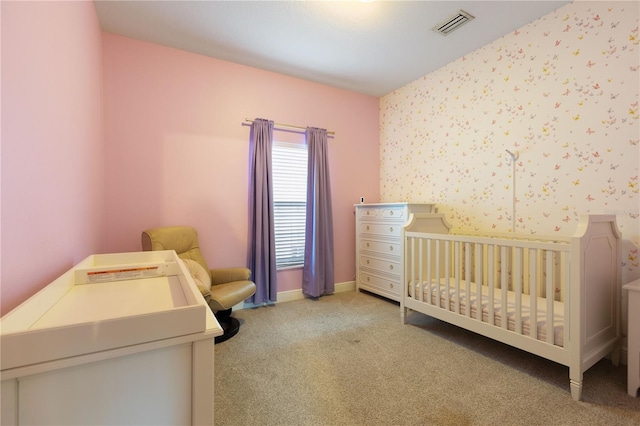 bedroom with a crib and light colored carpet