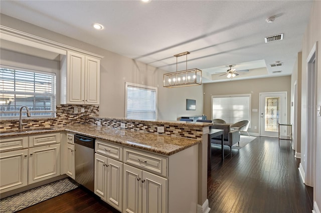 kitchen featuring kitchen peninsula, decorative backsplash, stainless steel dishwasher, ceiling fan, and sink