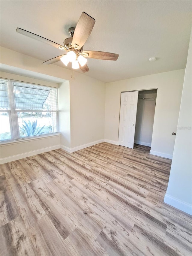 unfurnished bedroom with light wood-type flooring, a closet, and ceiling fan