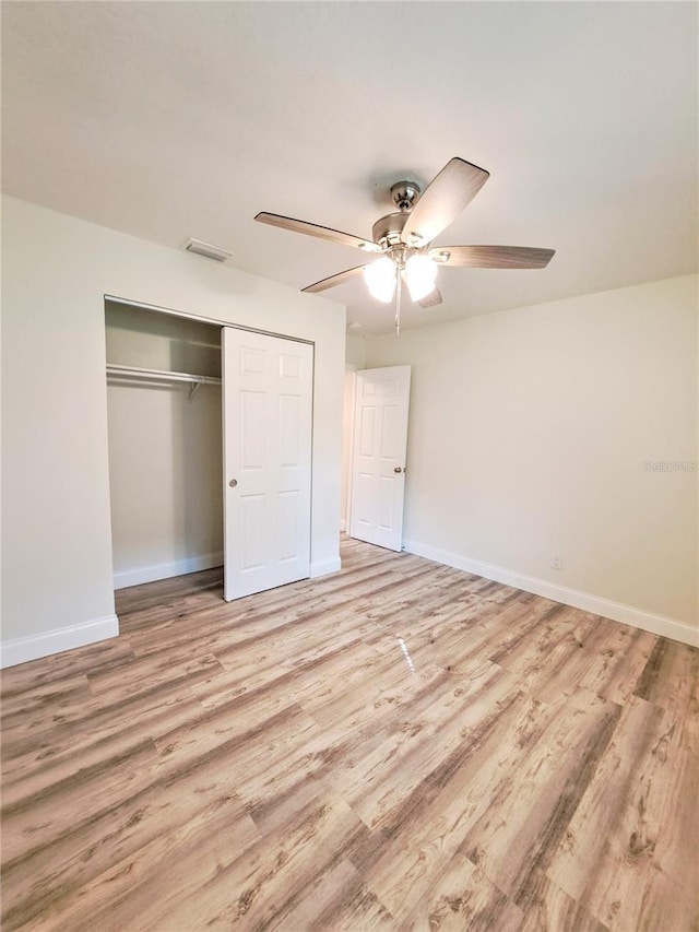 unfurnished bedroom with ceiling fan, a closet, and light wood-type flooring