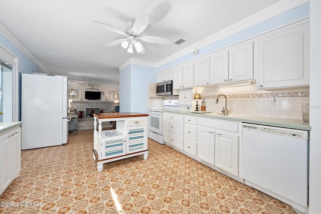 kitchen featuring ceiling fan, white cabinetry, a stone fireplace, and white appliances