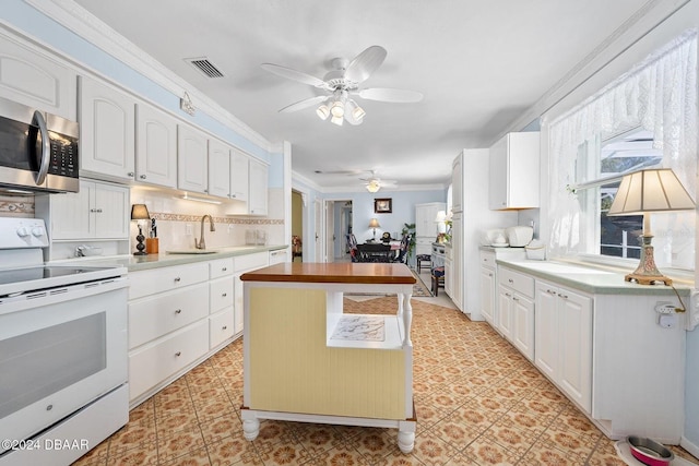 kitchen with wood counters, sink, ornamental molding, white range with electric stovetop, and white cabinetry