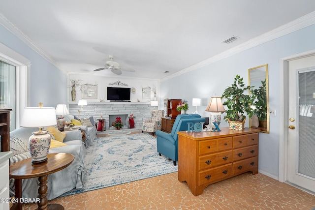 living room with ceiling fan, a stone fireplace, and ornamental molding