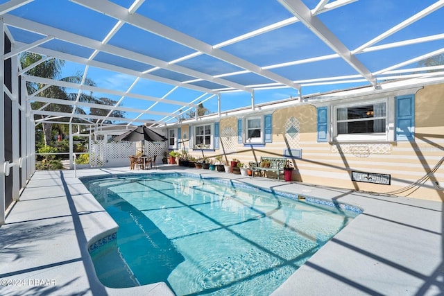 view of swimming pool featuring glass enclosure and a patio area