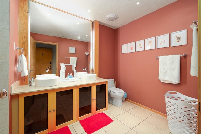 bathroom featuring tile patterned flooring, vanity, a textured ceiling, and toilet