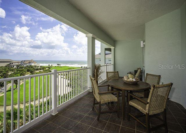 balcony featuring a water view and a view of the beach