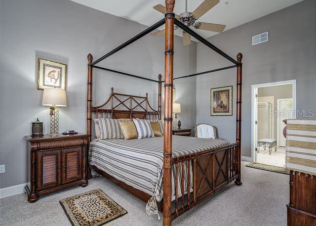 bedroom with ceiling fan, a towering ceiling, and carpet floors