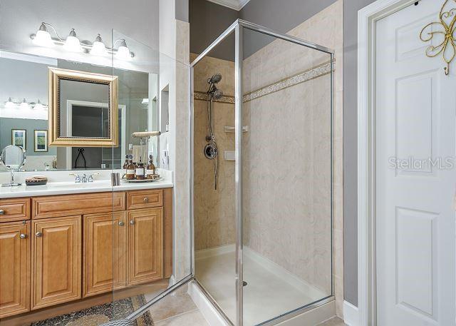 bathroom with tile patterned floors, vanity, and a shower with door