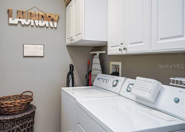 laundry area with cabinets and washing machine and clothes dryer