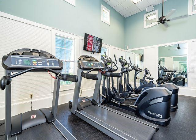 workout area with a drop ceiling and ceiling fan