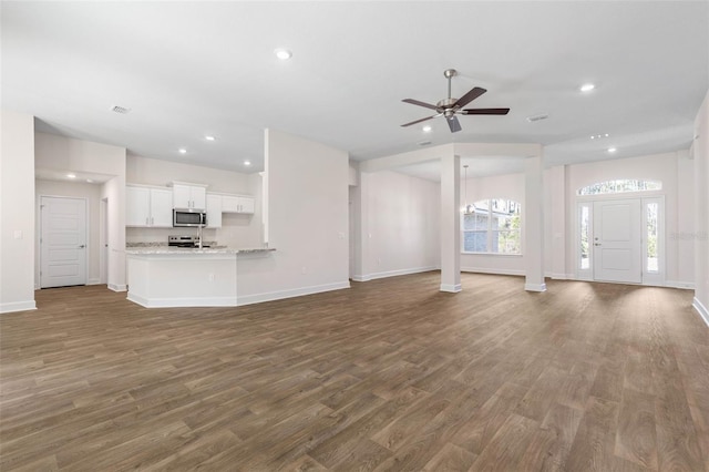 unfurnished living room with ceiling fan and dark hardwood / wood-style floors