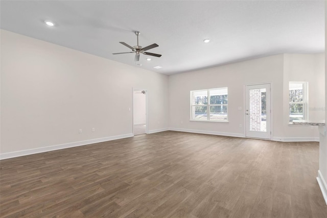 unfurnished living room featuring ceiling fan and dark wood-type flooring