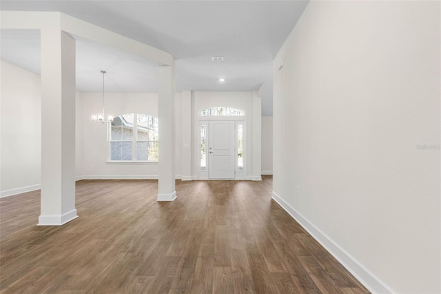 foyer with vaulted ceiling, dark wood-type flooring, and a chandelier