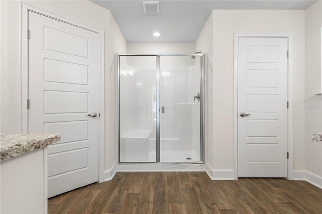 bathroom with vanity, hardwood / wood-style flooring, and a shower with door