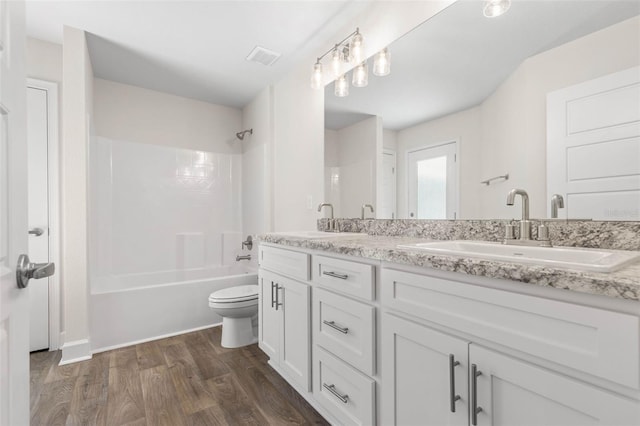 full bathroom featuring toilet, vanity, wood-type flooring, and shower / tub combination