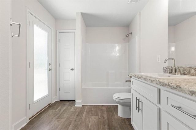 full bathroom featuring hardwood / wood-style flooring, shower / bath combination, toilet, and vanity