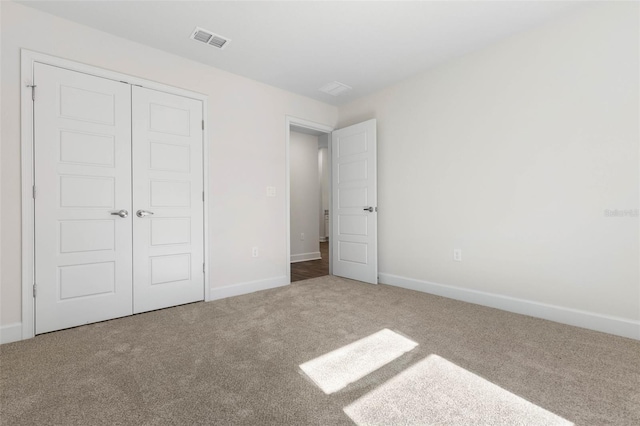 unfurnished bedroom featuring carpet and a closet