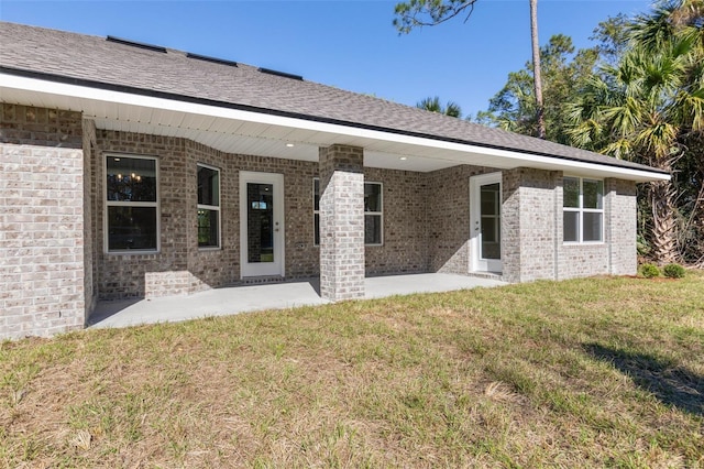 rear view of house featuring a lawn and a patio area