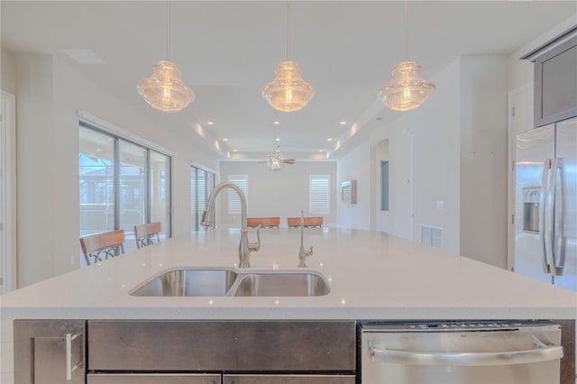 kitchen with pendant lighting, dishwasher, a center island with sink, sink, and white fridge with ice dispenser