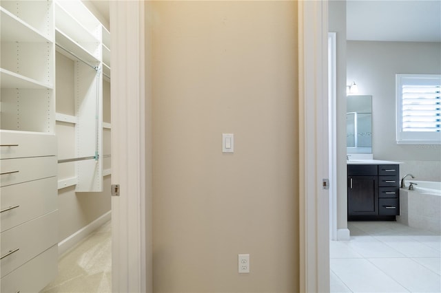 interior space featuring tile patterned floors, vanity, and tiled bath