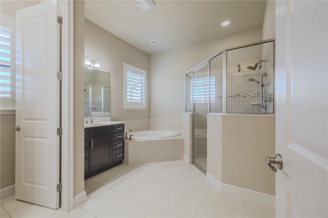 bathroom featuring shower with separate bathtub, vanity, and tile patterned floors