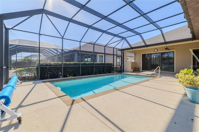 view of pool with glass enclosure, ceiling fan, and a patio