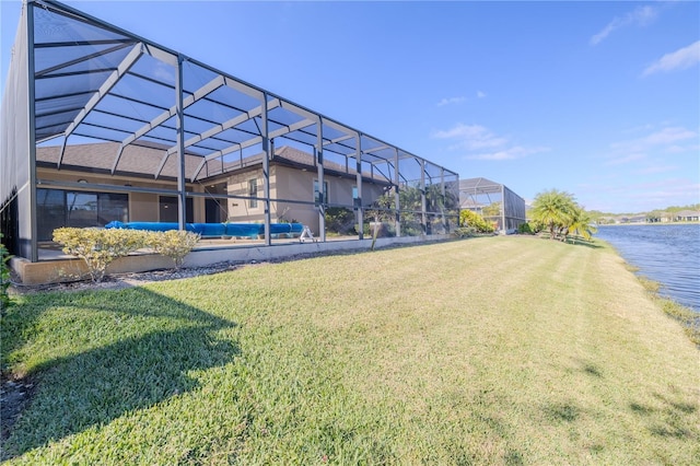 view of yard featuring glass enclosure and a water view