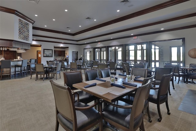 dining area with light carpet and crown molding