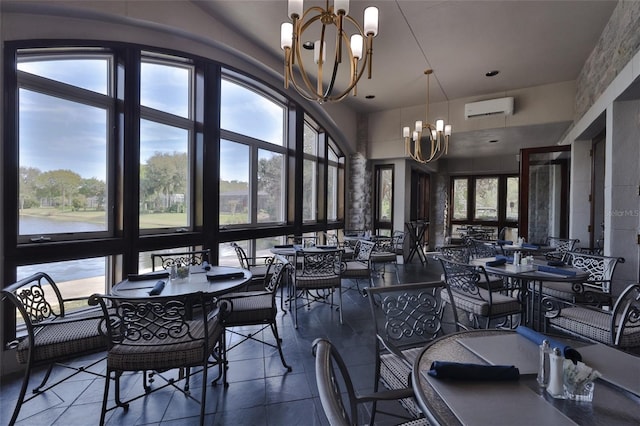 dining room with plenty of natural light, an AC wall unit, a high ceiling, and an inviting chandelier