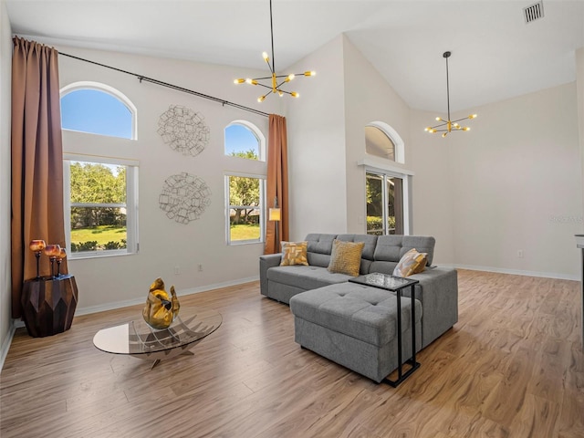 living room with a chandelier, light hardwood / wood-style flooring, and plenty of natural light