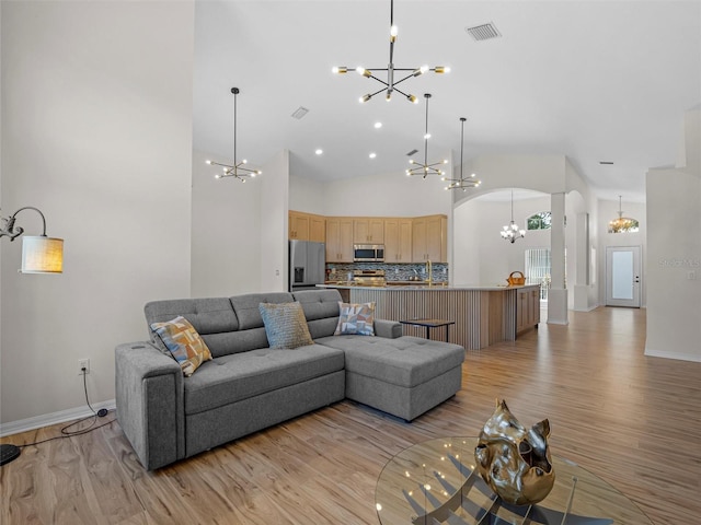 living room with light hardwood / wood-style floors and high vaulted ceiling