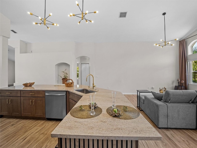 kitchen featuring dishwasher, sink, an island with sink, and light hardwood / wood-style flooring