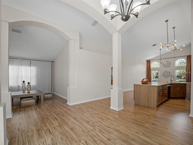 living room with light wood-type flooring, high vaulted ceiling, and an inviting chandelier