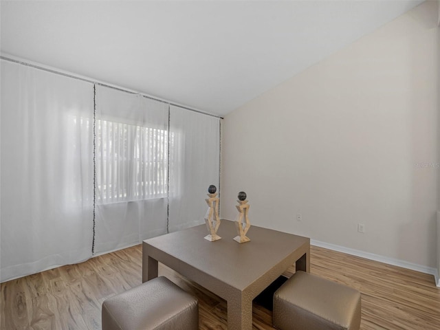 dining area with light hardwood / wood-style floors and vaulted ceiling