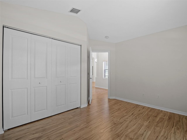 unfurnished bedroom featuring light wood-type flooring and a closet