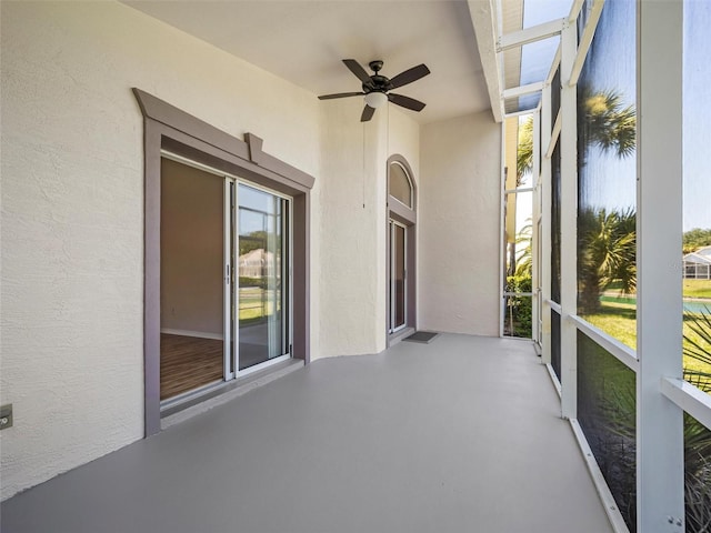 unfurnished sunroom with ceiling fan