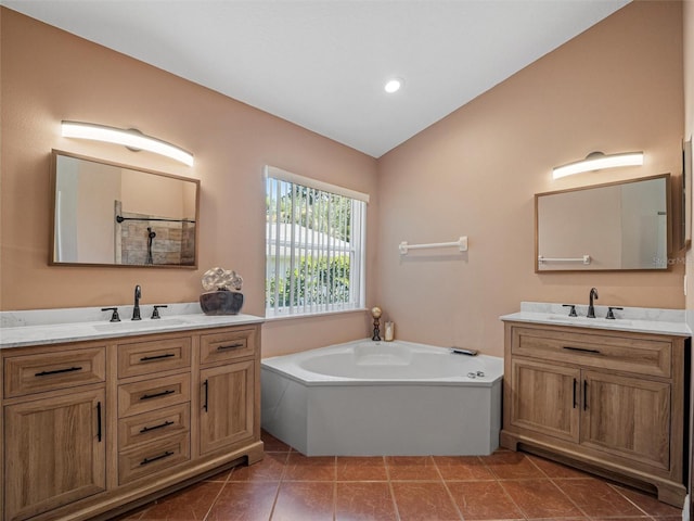 bathroom with vanity, a tub to relax in, tile patterned floors, and lofted ceiling