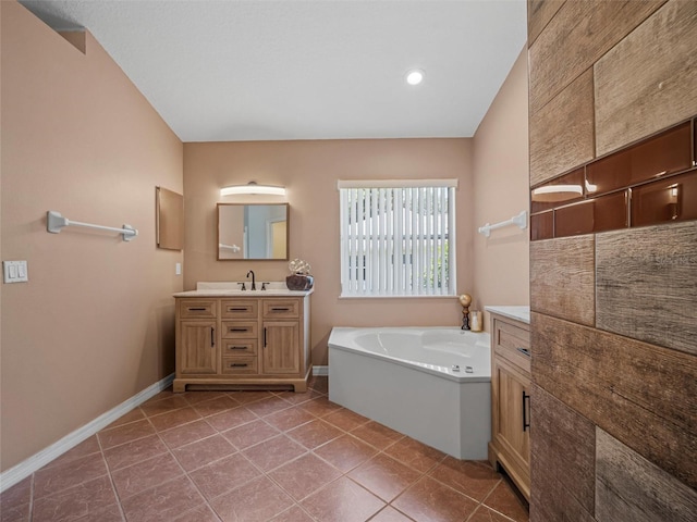 bathroom with vanity, tile patterned floors, a bathtub, and vaulted ceiling