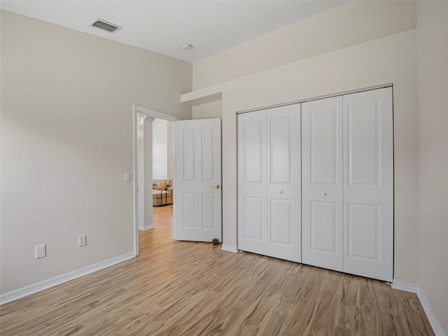 unfurnished bedroom with light hardwood / wood-style floors and a closet