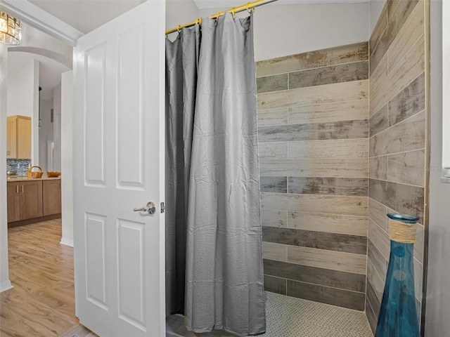 bathroom with hardwood / wood-style flooring and walk in shower