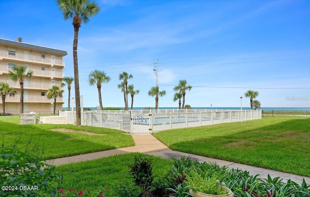 view of community with a yard and a water view