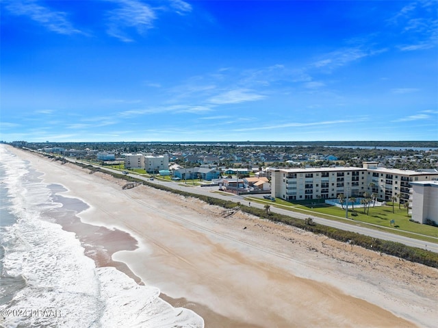 birds eye view of property with a water view and a beach view