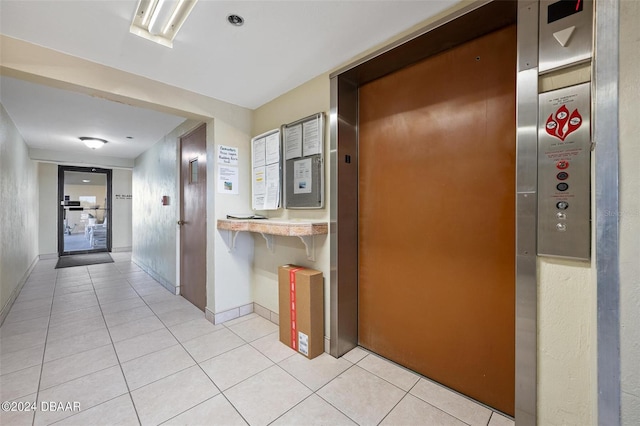 hall with elevator and light tile patterned flooring